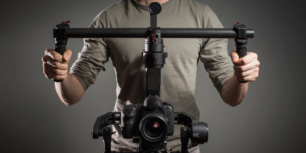 A professional videographer holding a gimbal