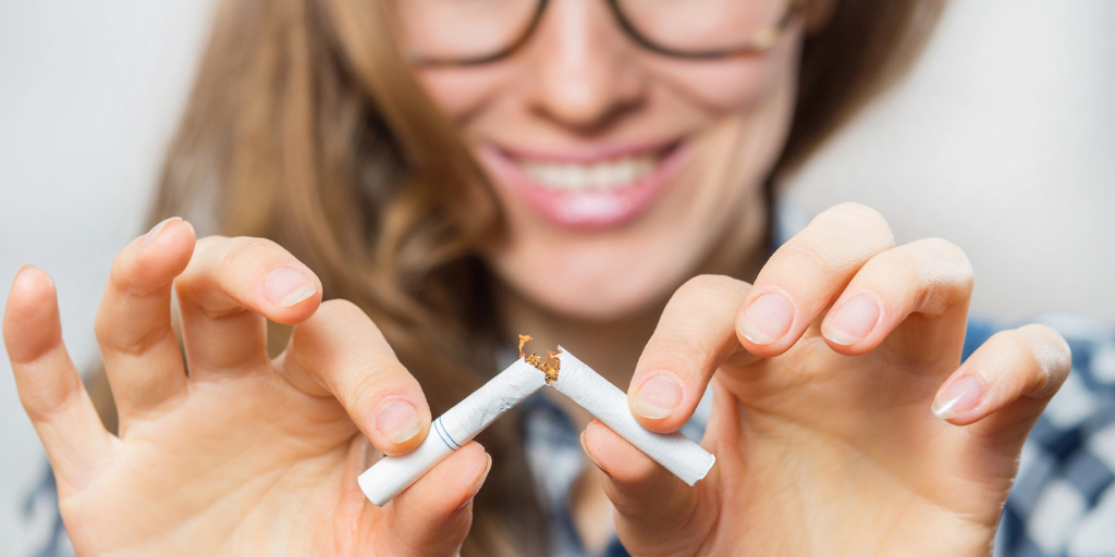 A woman breaking a cigarette in half